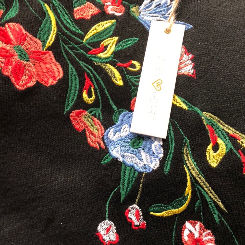 Ruffled sleeve sweater with embroidered flower